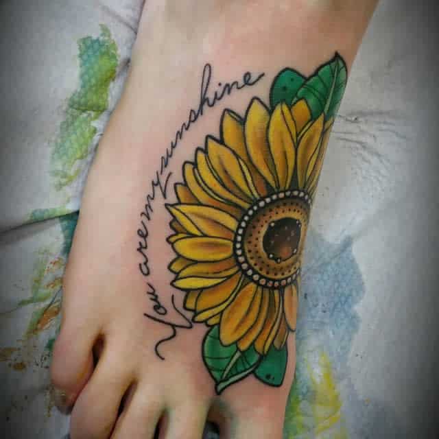 Foot tattoo of a sunflower with the text "You are my sunshine"