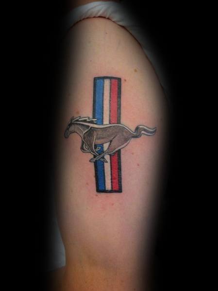 Ford Mustang logo tattoo on upper arm, featuring the iconic running horse over red, white, and blue racing stripes in a classic design.