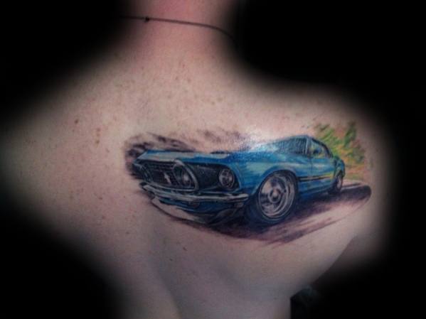 Vibrant blue Ford Mustang tattoo on upper back, featuring a dynamic motion effect with realistic shading and a scenic background.