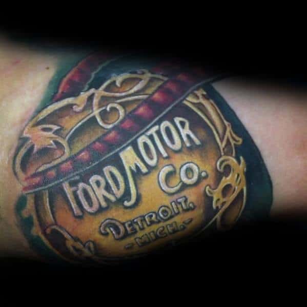 Vintage Ford Motor Co. tattoo with an ornate gold emblem, intricate detailing, and a realistic 3D effect, honoring the brand's Detroit roots.