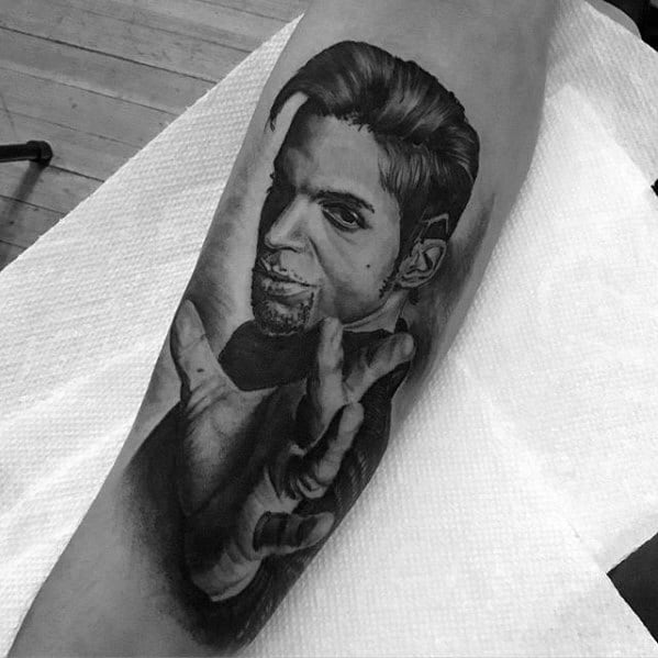 Black and white tattoo of a Prince with outstretched hand on someone's arm