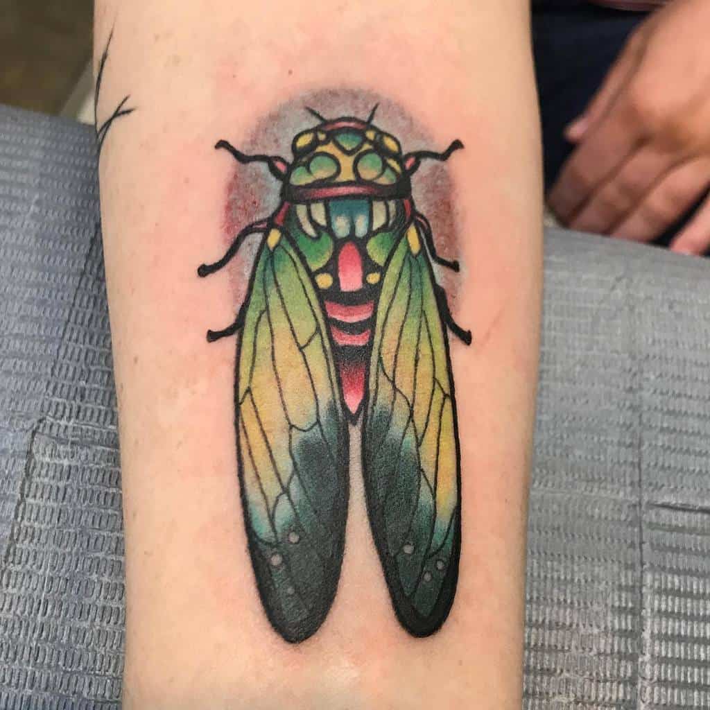 Tattoo of a colorful cicada on an arm