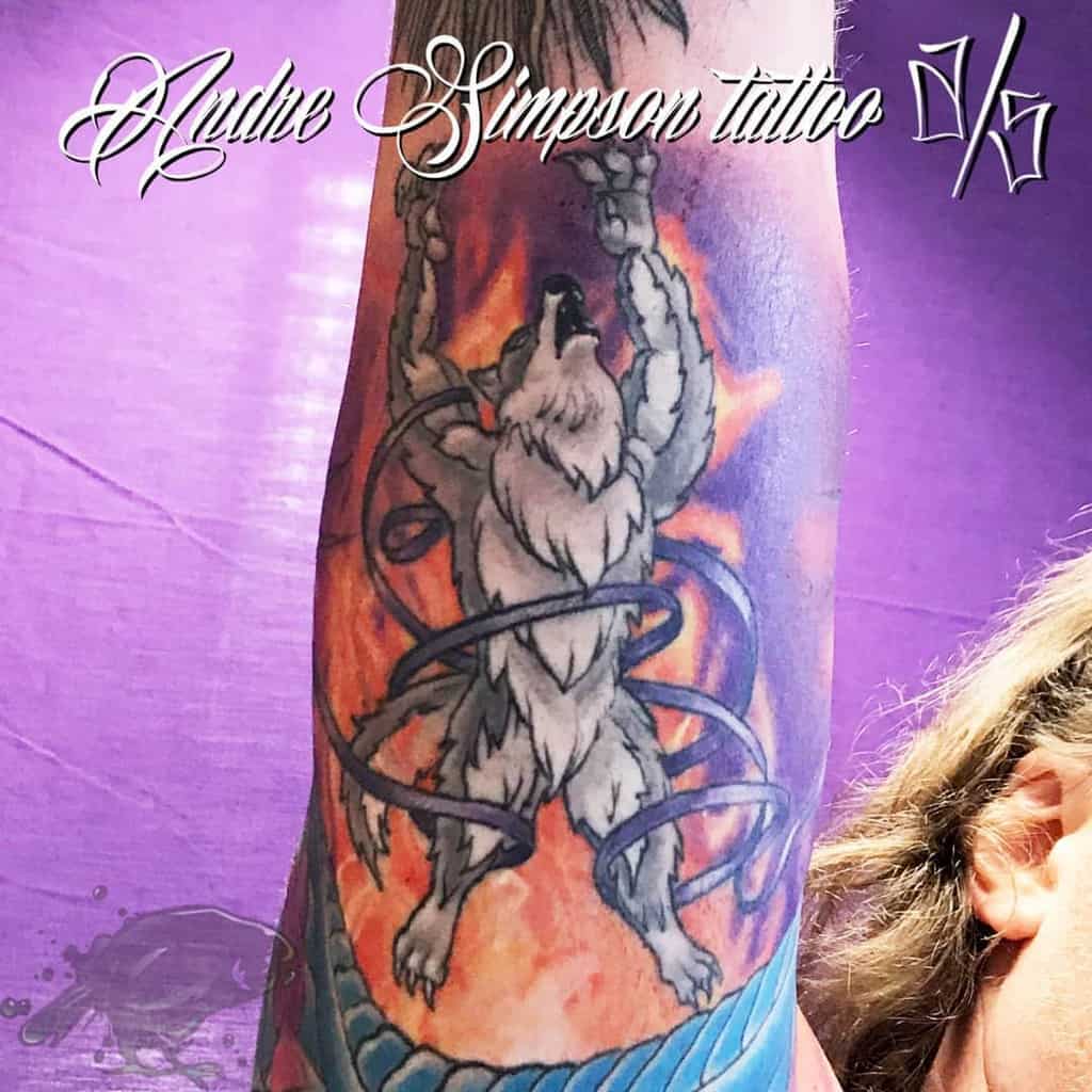 Norse-inspired wolf tattoo with fiery background, dynamic pose, and entwined chains, symbolizing strength and resilience
