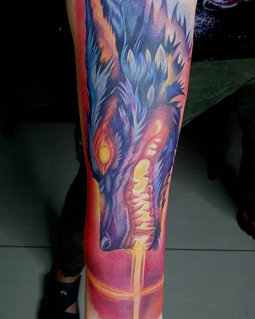 Vivid Norse wolf tattoo with fiery hues and striking details, symbolizing power, ferocity, and mystical energy