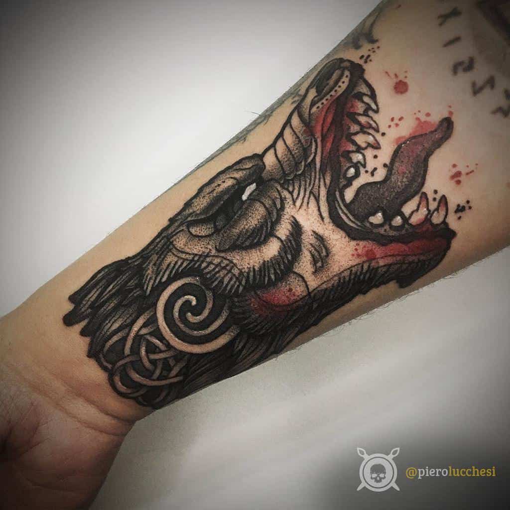 Forearm tattoo of Fenrir's snarling head with vivid red accents, Nordic knotwork, and bold, detailed shading