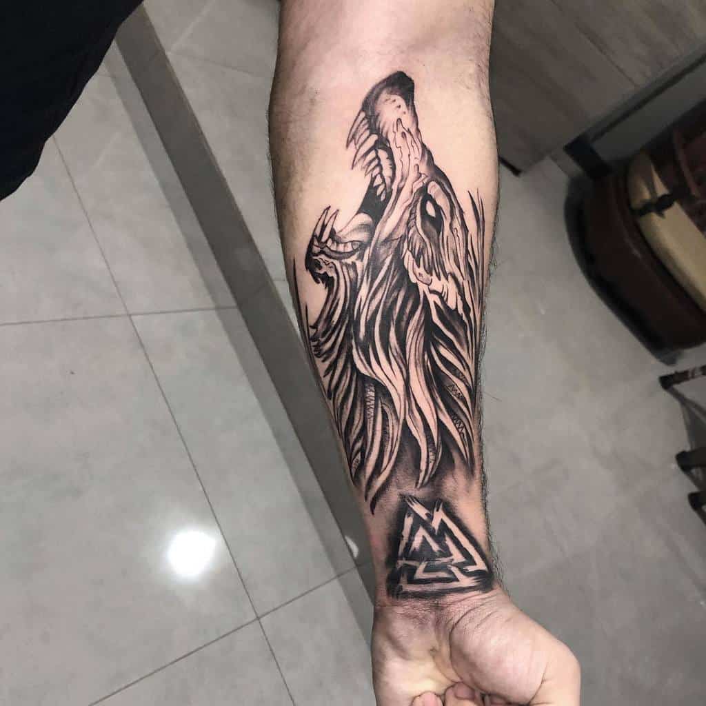 Forearm tattoo depicting Fenrir, the mythical Norse wolf, with sharp lines and a Valknut symbol below