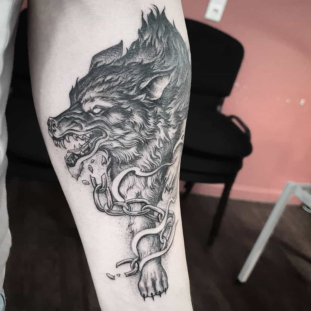 Forearm tattoo of Fenrir breaking free from chains, depicted with intricate fur details and a fierce expression