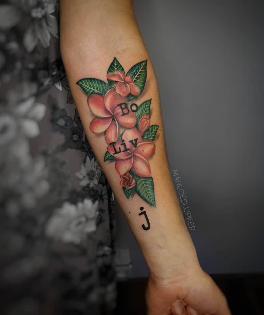 Forearm tattoo featuring pink plumeria flowers with lush green leaves, personalized with the names 'Bo' and 'Liv,' designed in a vibrant and detailed style