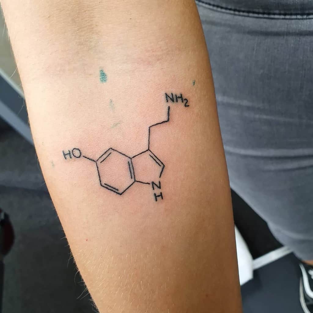 Serotonin molecule artfully inked on an arm