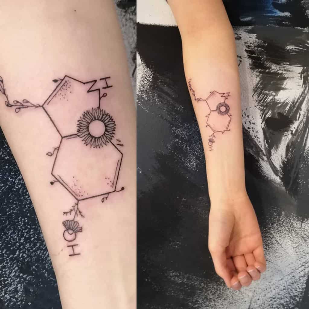 Forearm tattoo of a bee and flowers around a dotted serotonin molecule, paired with 'fortunato' script on the other arm