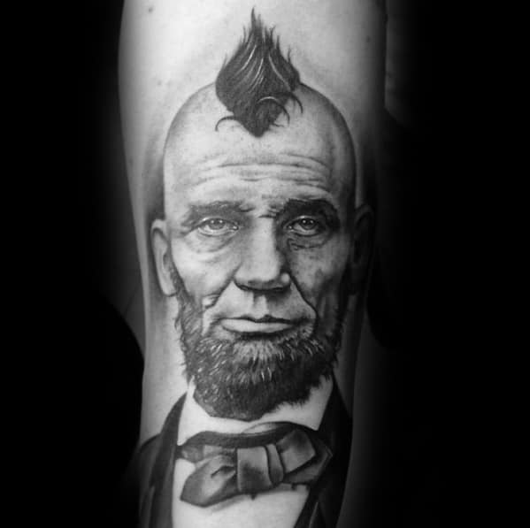 Tattoo of a man with a mohawk, beard, and bow tie, channeling Abraham Lincoln in style