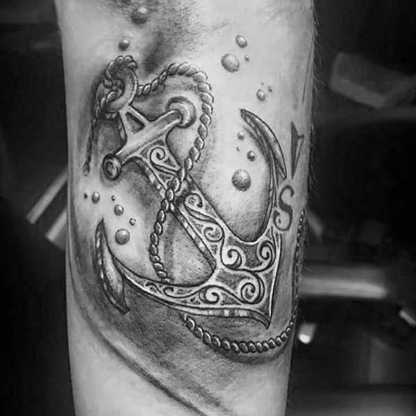 Black and grey tattoo of a detailed anchor with intricate patterns, surrounded by floating bubbles, creating a nautical and vintage-inspired design.