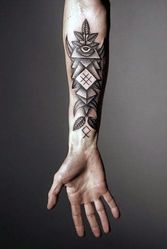 Forearm with geometric tattoo featuring an eye and various shapes and symbols
