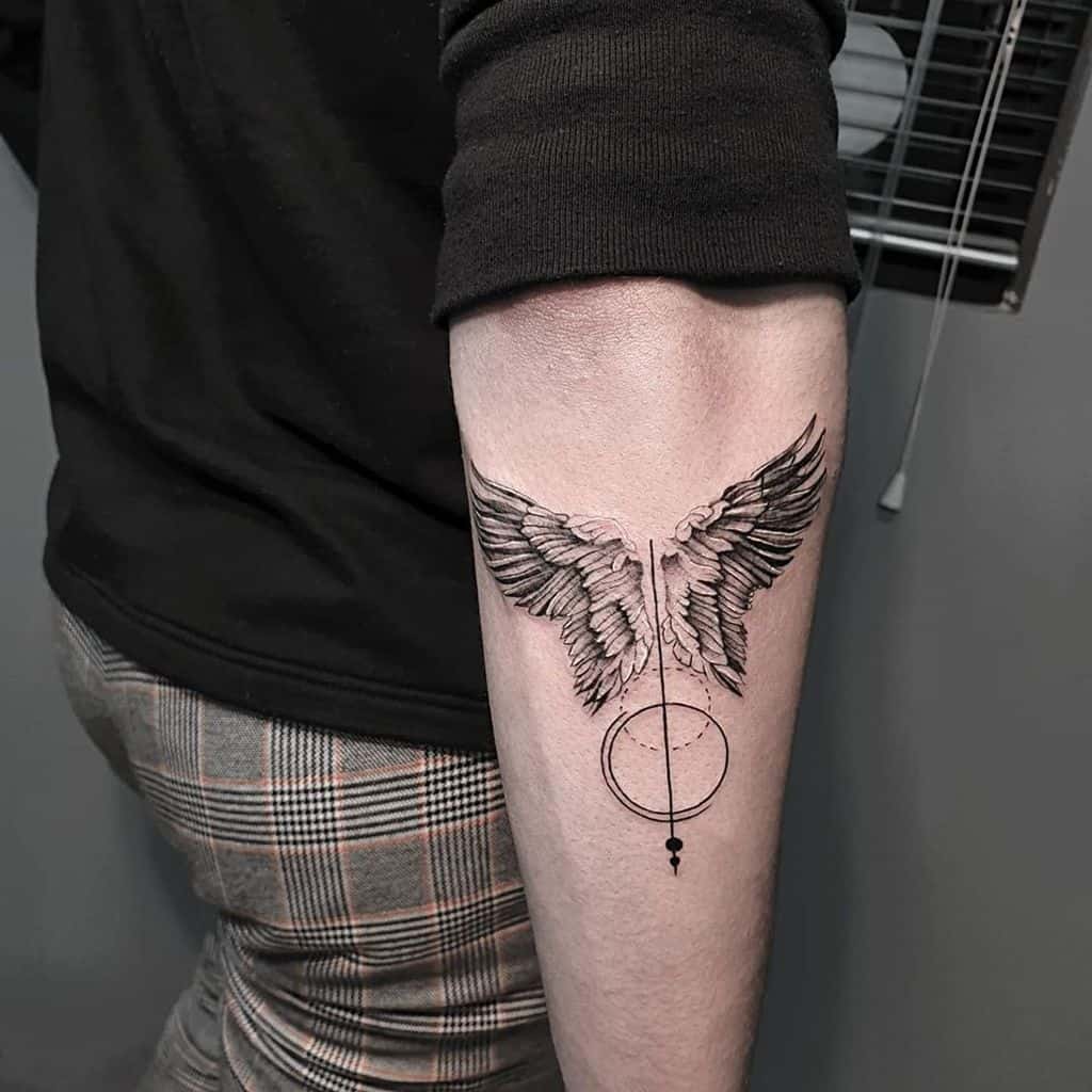 Angel wings tattoo, with geometric shapes like a circle and a vertical line integrated into the design