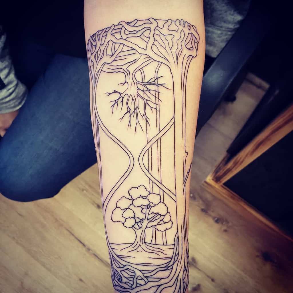 Linework forearm tattoo of an hourglass with interconnected trees, roots, and branches symbolizing the passage of time and duality