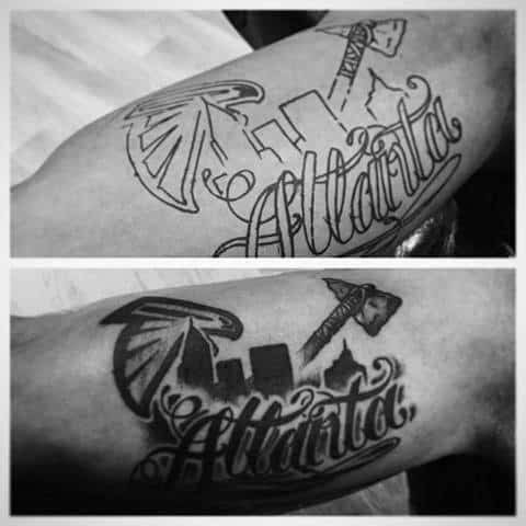 Black and gray forearm tattoo featuring Atlanta skyline, Falcons logo, tomahawk, and bold script reading Atlanta.