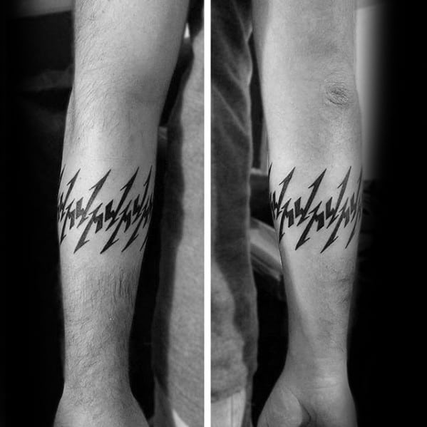 Black forearm band tattoo made of repeating sharp Metallica M logos forming a bold, symmetrical pattern around the arm.