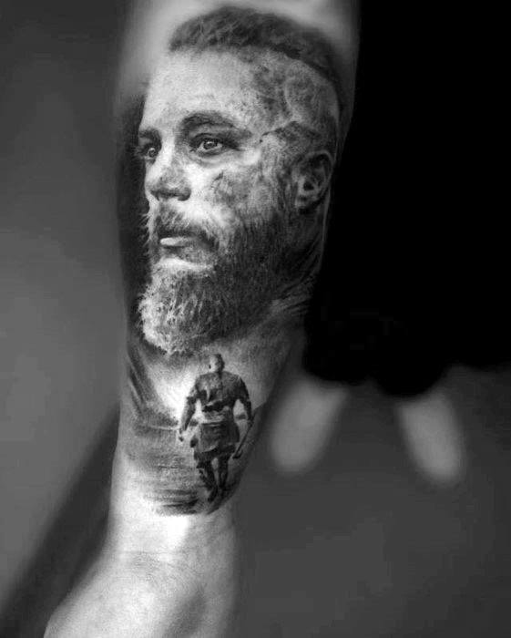 Black and gray tattoo: bearded man portrait above, full-body figure walking below, on a forearm