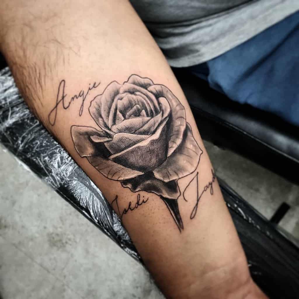 A realistic rose tattoo with names on an arm