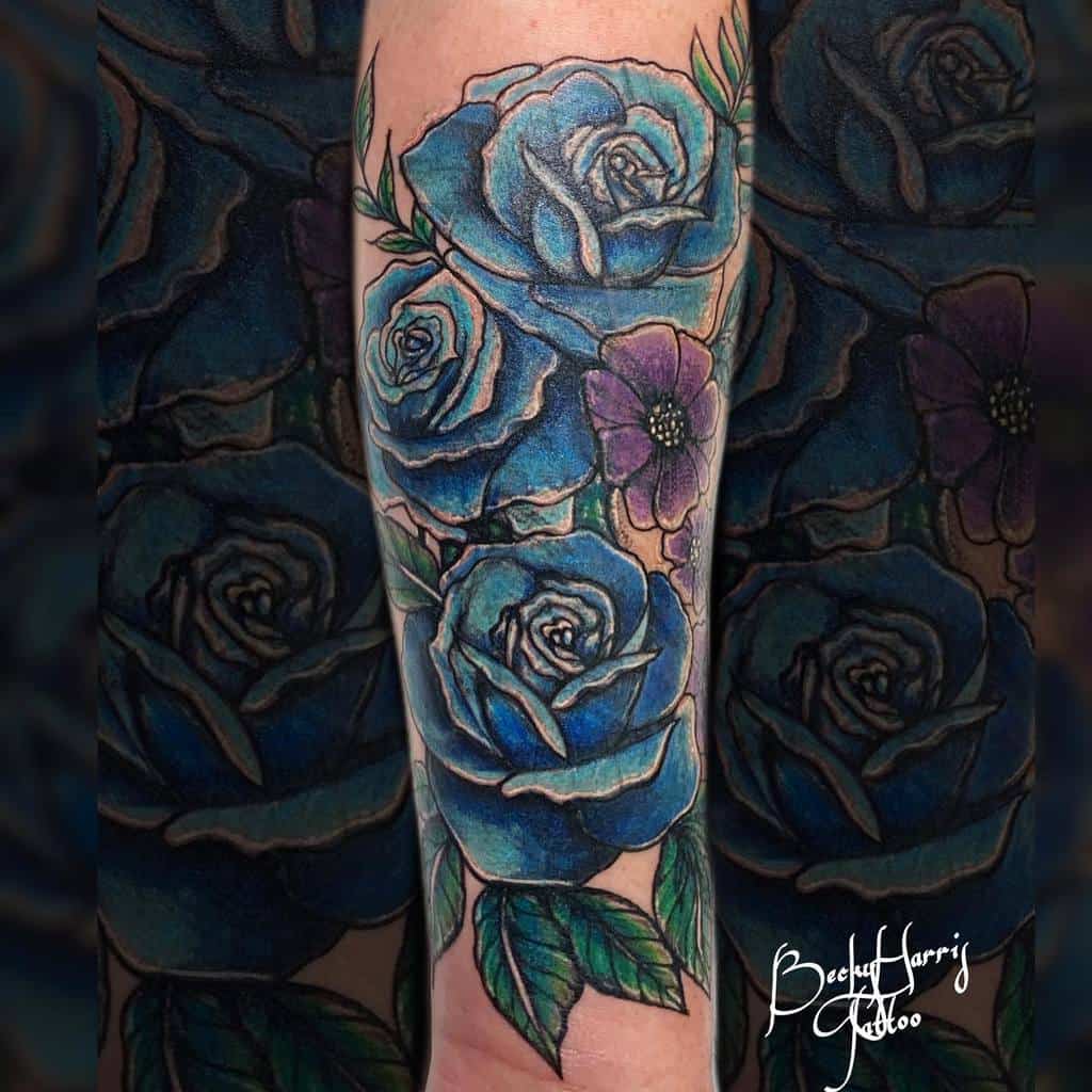 A mesmerizing tattoo featuring a stunning blue rose intertwined with a vibrant purple flower adorns the person's arm