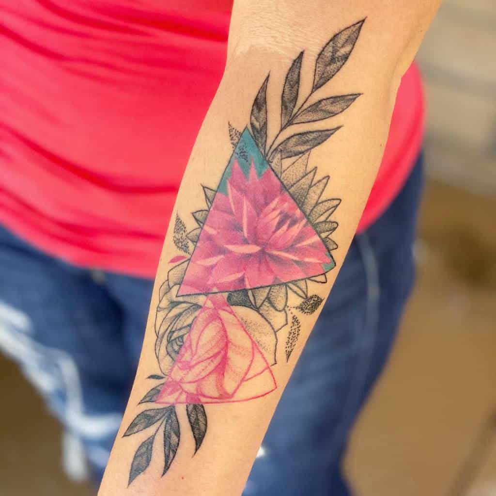 Colorful geometric flower tattoo on an arm, with leaves surrounding the design