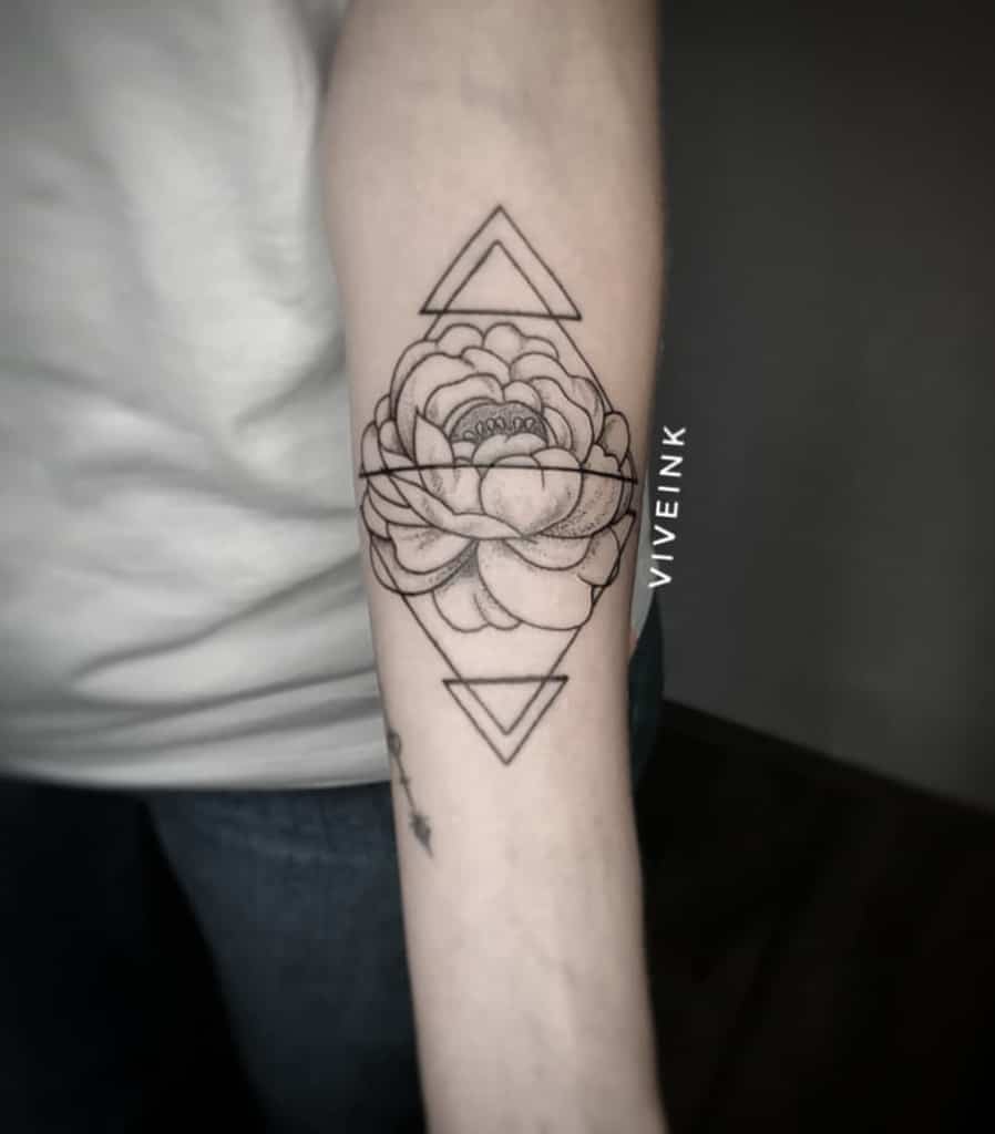 Forearm tattoo of a geometric design with a flower and two triangles