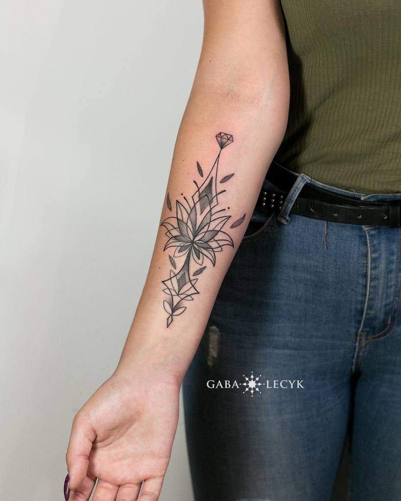 A geometric floral tattoo on a woman's forearm