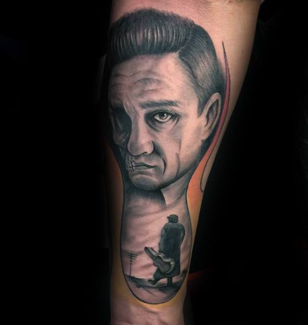 Tattoo of Johnny Cash's face above a figure walking with a guitar under a dark, cloudy sky