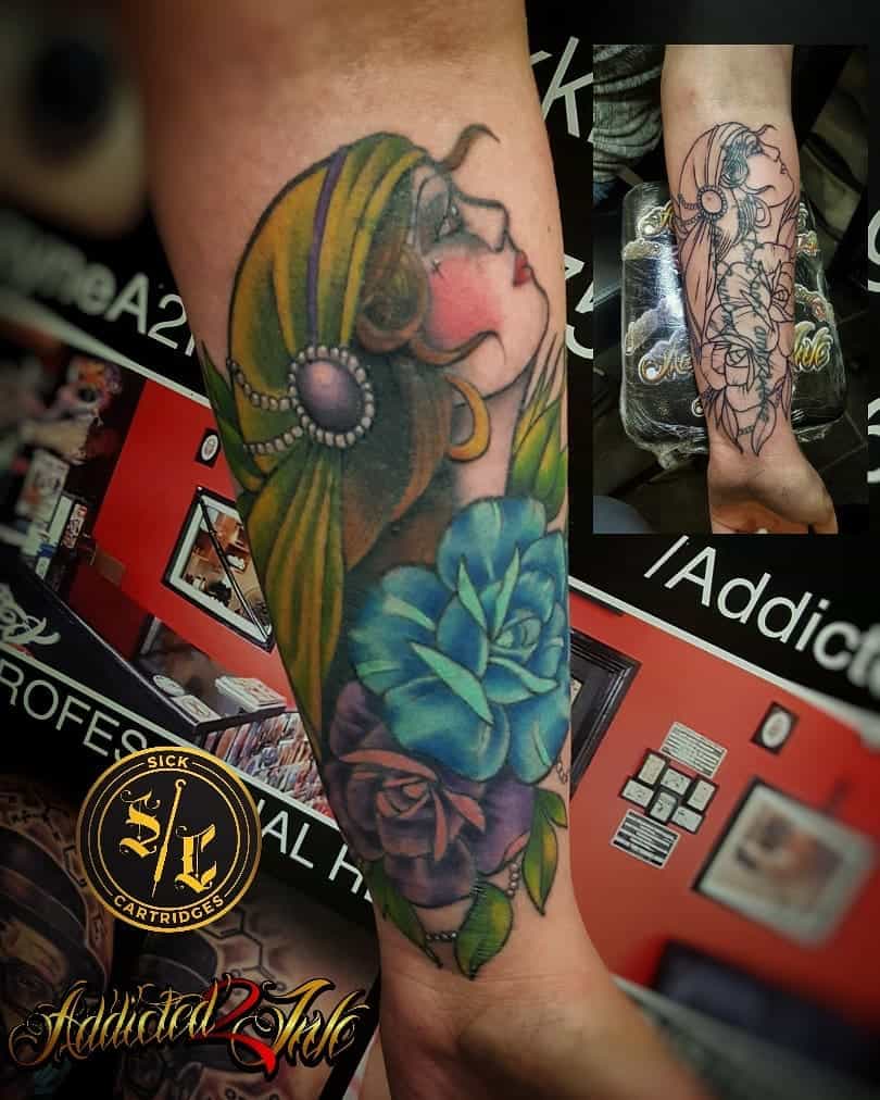 A vibrant tattoo of a gypsy woman adorned with flowers graces an arm, beautifully captured in a detailed sketch of the design