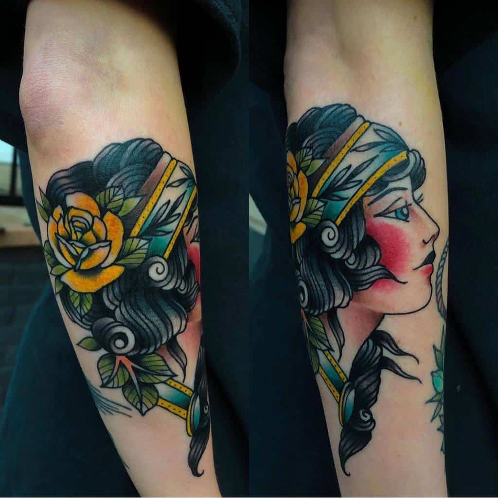 Colorful tattoo of a gypsy woman's profile with flowers and geometric shapes adorning an arm