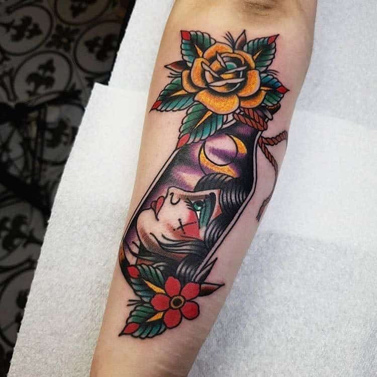 A vibrant tattoo of a gypsy woman adorned with flowers graces the arm, rendered in a colorful traditional style