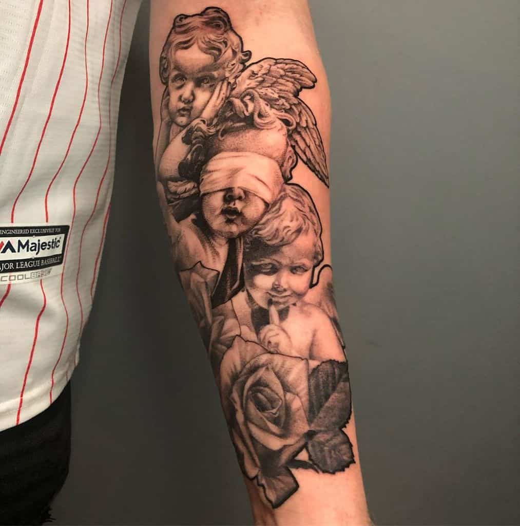Forearm tattoo of three cherubs symbolizing 'Hear No Evil, See No Evil, Speak No Evil,' with detailed roses and angel wings