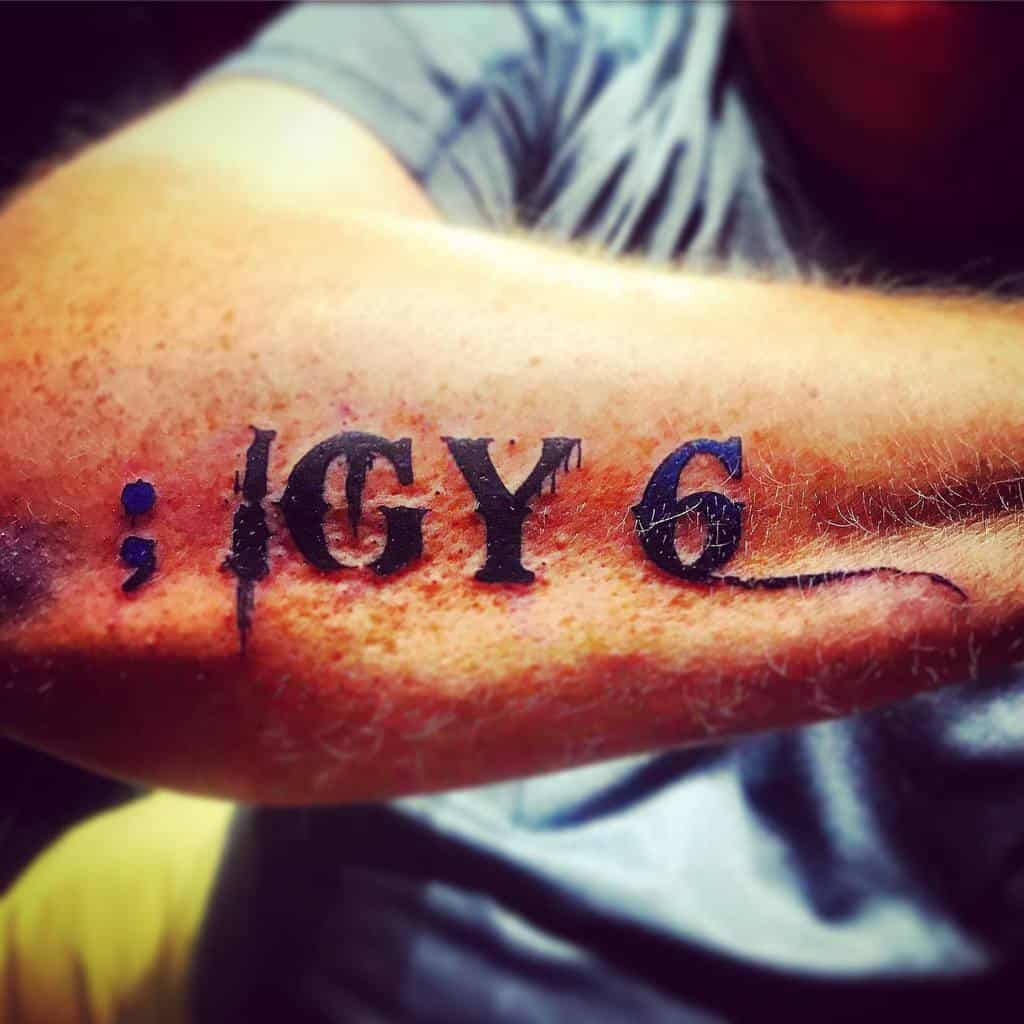 Forearm tattoo with text "; IGY 6" in bold black letters