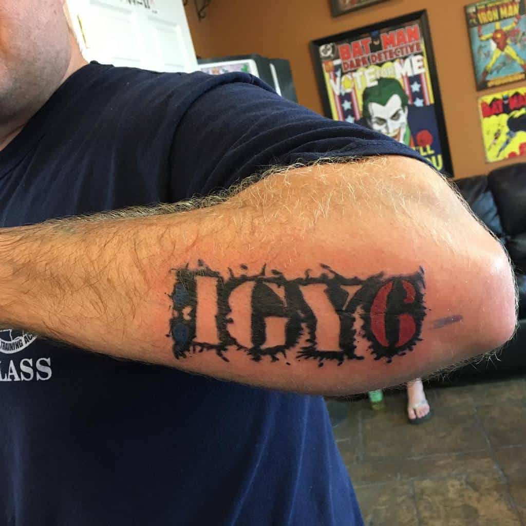 A forearm tattoo with ";IGY6" in bold, stylized letters