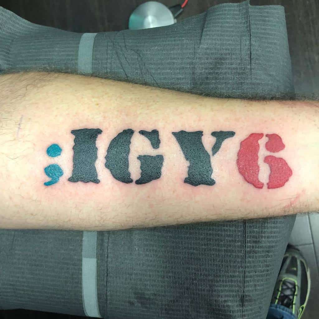 Tattoo reading "; IGY6" with a red "6" and the rest in black, on a forearm