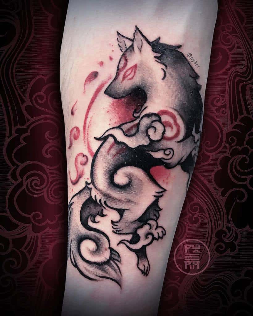 Tattoo of a mythical wolf with swirling patterns and red accents on an arm