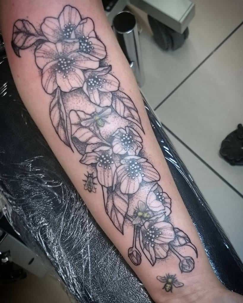 Forearm tattoo with an intricate floral design in black ink