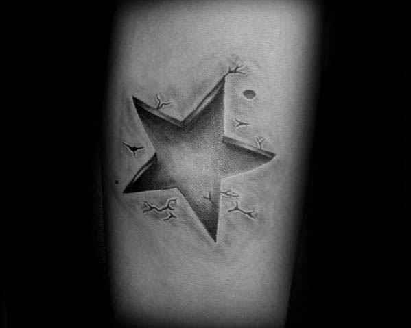 Minimalist 3D star tattoo with carved-out effect and subtle cracks around the edges, giving the illusion of depth on the skin.