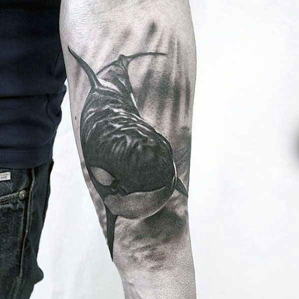 Realistic black and gray orca tattoo on the forearm, capturing the whale's graceful profile with fine shading and lifelike details.