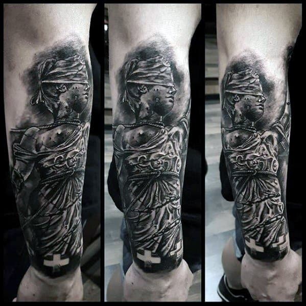 Realistic black and grey tattoo of Lady Justice on forearm, inspired by Metallica’s ...And Justice for All album artwork.