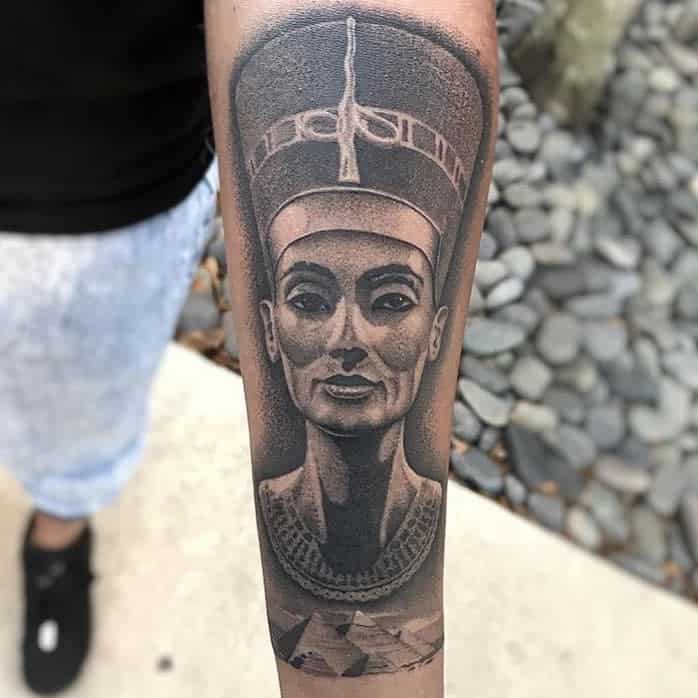 Tattoo of Nefertiti with pyramids, adorning a forearm