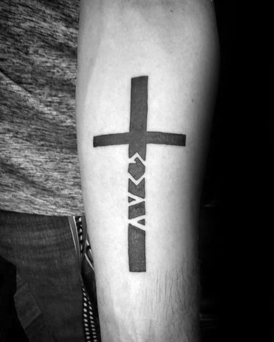 Tattoo combining a bold cross with "God is greater than the highs and lows" symbols seamlessly integrated