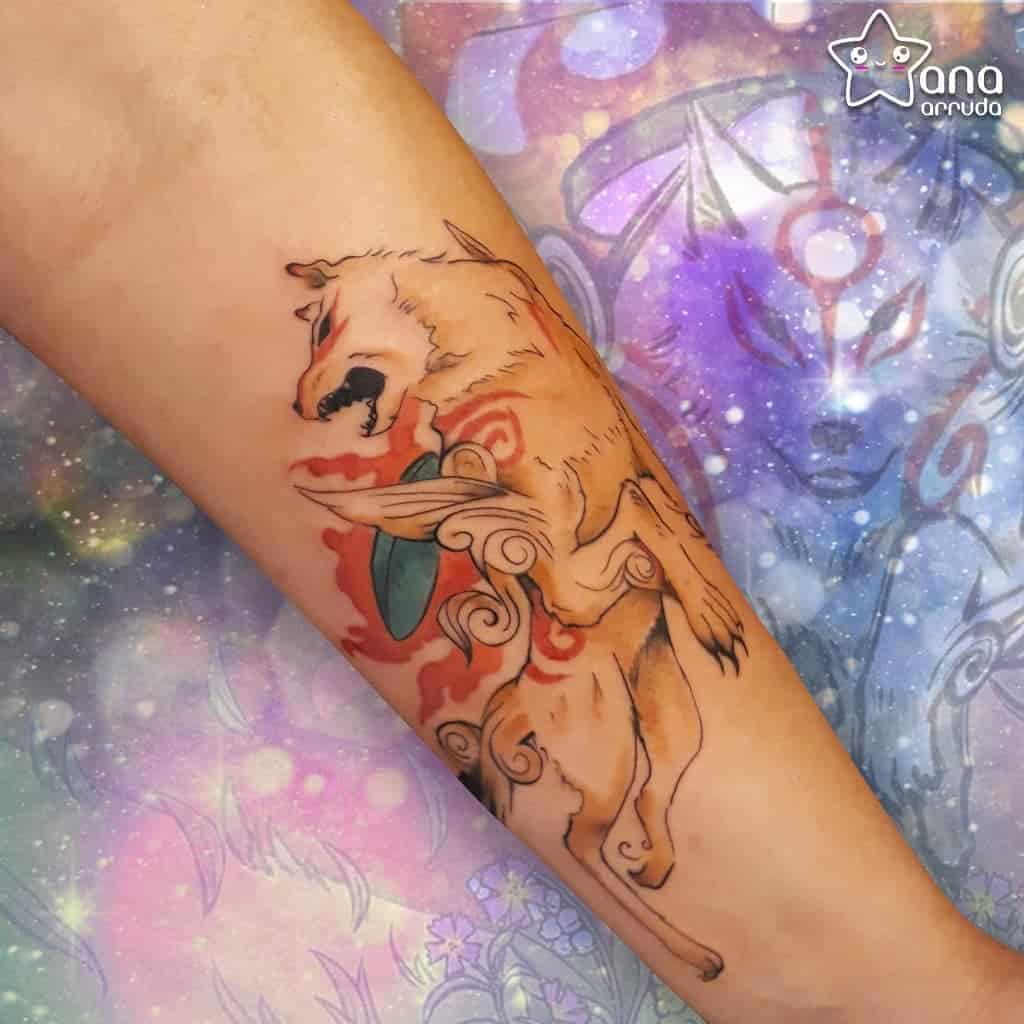 Vibrant Okami tattoo on the forearm featuring Amaterasu in motion with flowing red markings, divine energy, and a mystical background