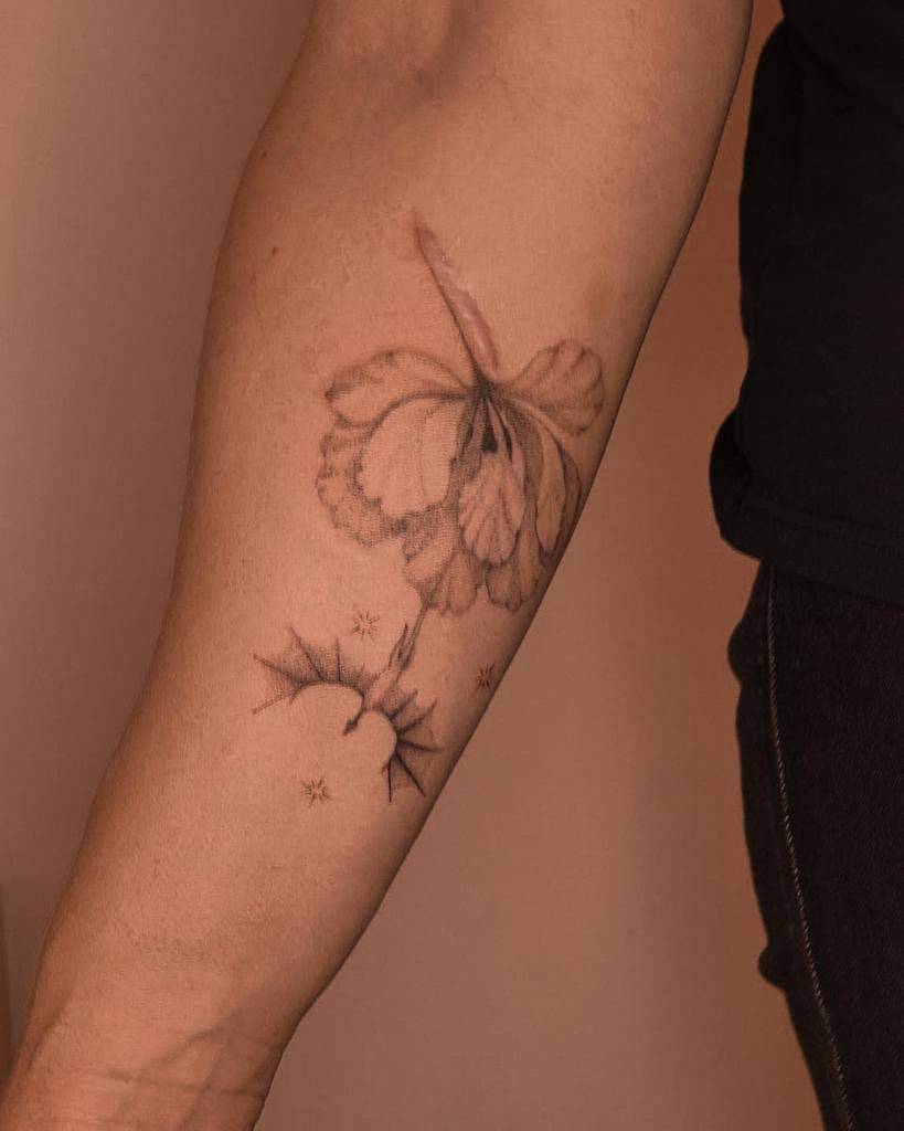 A single needle butterfly tattoo artfully integrated with a forearm scar