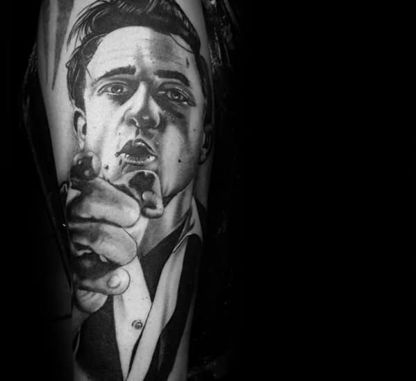 Black and white tattoo of Johnny Cash pointing forward on an arm