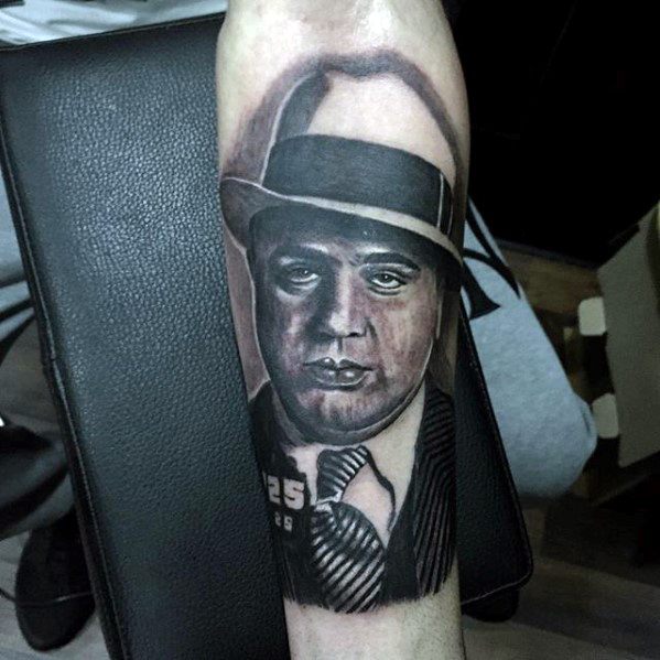 Al Capone tattoo featuring a black-and-white portrait of the gangster with his inmate number "925" visible, and wearing his classic fedora and suit.