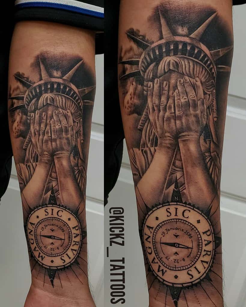 Forearm tattoo featuring a detailed Statue of Liberty covering her face and a compass design with 'Sic Parvis Magna' text below'