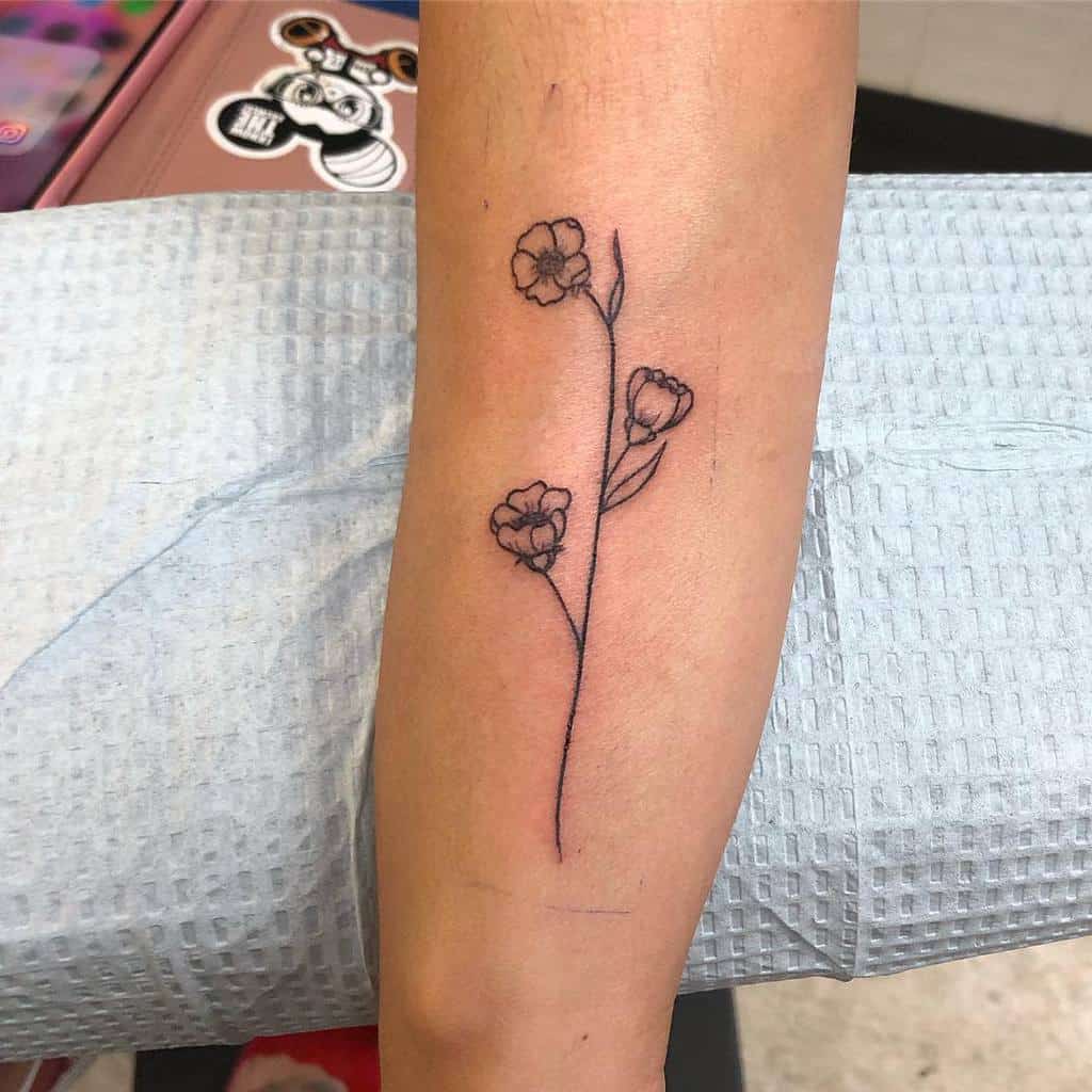 Tattoo of a delicate flower with three small blossoms on a forearm