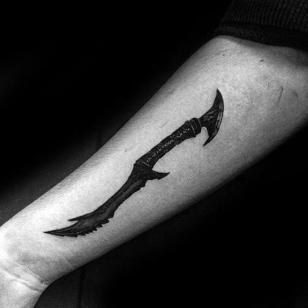 Arm with a black tattoo of a stylized, curved Skyrim weapon