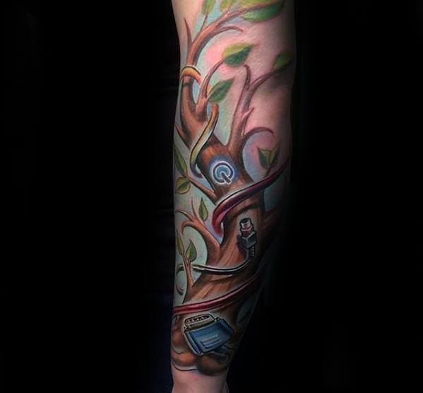 Colorful tattoo of a tree with tech elements like a monitor, USB plug, and power button, blending nature with digital life.